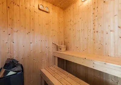 a wooden sauna with a bench and a trash can at Villa Antico Pozzo piscina privata SPA in Castellammare del Golfo