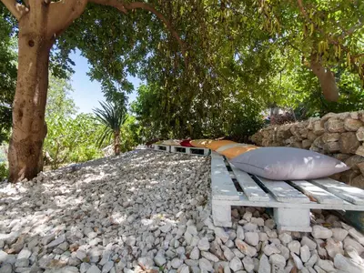 a bottle of wine and fruit on a rock at Villa Antico Pozzo piscina privata SPA in Castellammare del Golfo