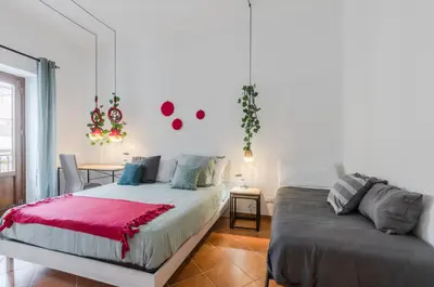 a bedroom with a bed and a desk and a table at GuestHost - Ballarò Cozy Apartment with Balconies in Palermo