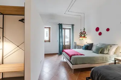 a bedroom with a bed and a table in a room at GuestHost - Ballarò Cozy Apartment with Balconies in Palermo