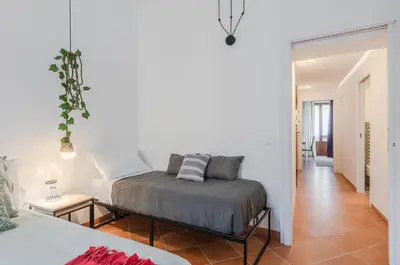 a bedroom with a bed in a room with a hallway at GuestHost - Ballarò Cozy Apartment with Balconies in Palermo