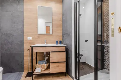 a bathroom with a sink and a mirror at GuestHost - Ballarò Cozy Apartment with Balconies in Palermo