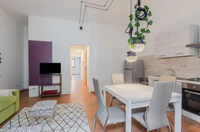 a kitchen and dining room with a white table and chairs at GuestHost - Ballarò Cozy Apartment with Balconies in Palermo