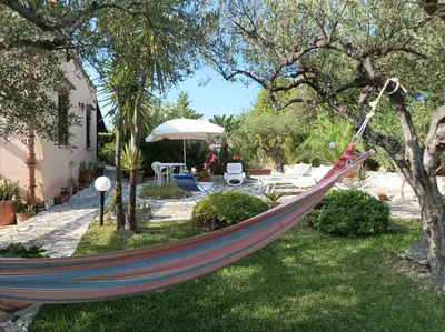 a hammock hanging from a tree in a yard at Villetta sulla Valle in Castellammare del Golfo