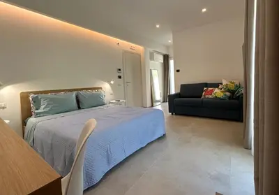 a bedroom with a bed and a desk and a window at Civetta Blu in Castellammare del Golfo
