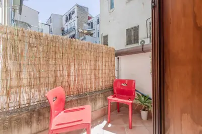two chairs and a table on a balcony at GuestHost - Teatro Politeama Functional Studio x4 in Palermo