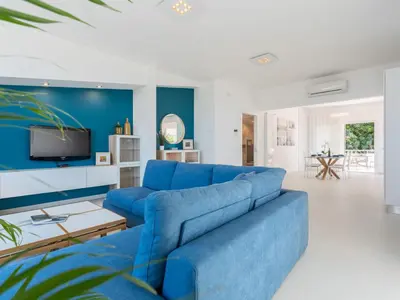 a blue couch in a living room with a tv at Apartment Quirat Superior by Interhome in Terrasini