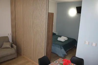 a bedroom with a bed and a couch and a chair at DUE CAPPUCCINI in Palermo