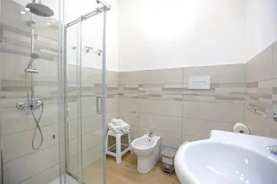 a bathroom with a shower and a toilet and a sink at DUE CAPPUCCINI in Palermo