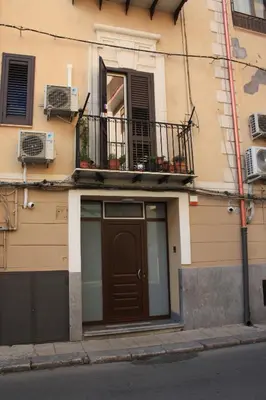 a building with a brown door and a balcony at DUE CAPPUCCINI in Palermo