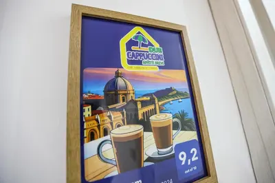 a framed poster of a city with two cups of beer at DUE CAPPUCCINI in Palermo
