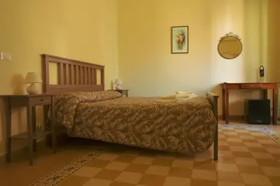 a bedroom with a bed and a table and a mirror at B&B Palazzo Corvino in Palermo