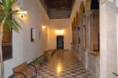 an empty hallway with benches in a building at B&B Palazzo Corvino in Palermo