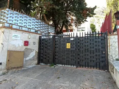 a fence with a gate in front of a building at Villa Margot Mondello in Palermo