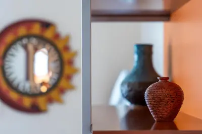 a vase sitting on a table next to a clock at Casa Lov (Politeama) in Palermo