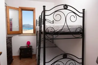 a bedroom with a black bunk bed with a window at Casa Sally con Vista Mare a Macari in Macari