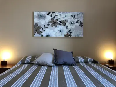 a bed with two pillows and a painting on the wall at Villa Gelvi in Castellammare del Golfo