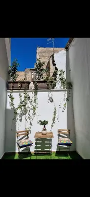 two chairs and a table with plants in a room at Giardino Moreno in Palermo