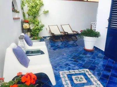 a patio with chairs and blue tiles on the floor at The k house in Palermo