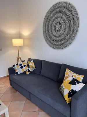 a blue couch with pillows in a living room at The k house in Palermo
