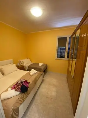 two beds in a room with yellow walls at Al Parlatoio del Centro Storico in Palermo