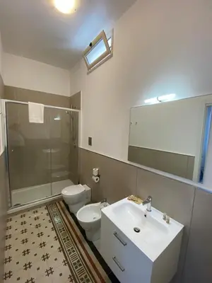 a bathroom with a sink and a toilet and a mirror at Al Parlatoio del Centro Storico in Palermo