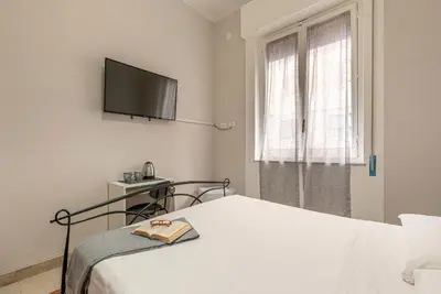 a bedroom with a bed and a tv on the wall at LA VECCHIA PALERMO in Palermo