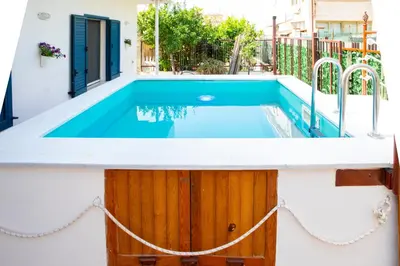 a swimming pool in a house with a white and blue at Beddamuri home in Carini