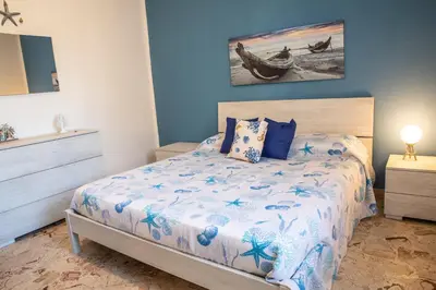 a bedroom with a bed and a painting on the wall at Beddamuri home in Carini