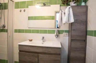 a bathroom with a sink and a mirror at Beddamuri home in Carini