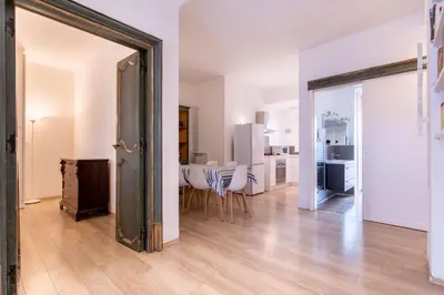 an open living room with a table and a kitchen at Eye on the Politeama - L'occhio sul Politeama in Palermo