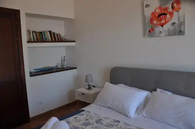 a bedroom with a bed and a book shelf at Villa Cala Rossa Antonella in Castellammare del Golfo