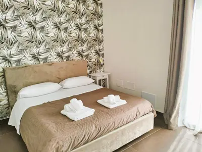 a bedroom with a bed with two towels on it at TorreNormanna Prestige House near Cefalù in Mandra Capreria