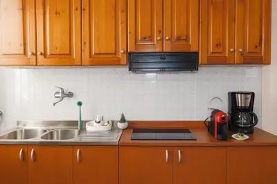 a kitchen with wooden cabinets and a sink at - Palermo - Sferracavallo sul mare in Palermo