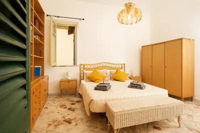 a bedroom with a bed with yellow pillows at - Palermo - Sferracavallo sul mare in Palermo