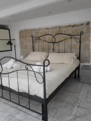 a black metal bed with white sheets and pillows at La casetta nel vicolo in Palermo