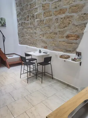 a table and chairs in a room with a stone wall at La casetta nel vicolo in Palermo