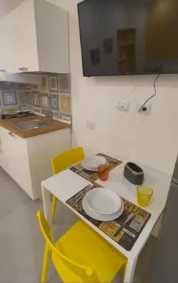 a small kitchen with a table and yellow chairs at Amunì o 123 in Palermo