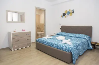 a bedroom with a bed and a dresser and a mirror at B&B Piano di Sopra in San Vito lo Capo