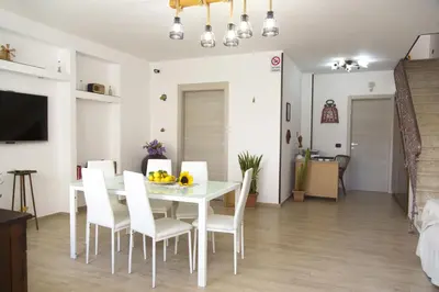 a dining room and living room with a white table and chairs at B&B Piano di Sopra in San Vito lo Capo