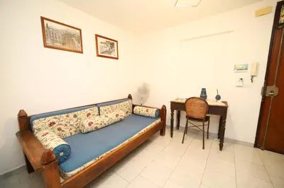 a bedroom with a bed and a living room at Colonna House Casa vacanze tra la Zisa e la Cattedrale in Palermo