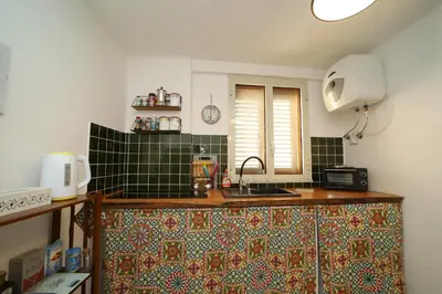 a bedroom with a bed and a chair and a lamp at Colonna House Casa vacanze tra la Zisa e la Cattedrale in Palermo