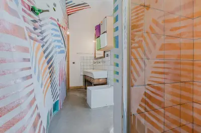 a bathroom with multicolored walls and a toilet at Ballarò Market Street Art Stylish Flat x10 in Palermo