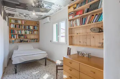 a room with a desk and a bed and bookshelves at Ballarò Market Street Art Stylish Flat x10 in Palermo