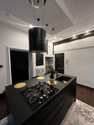 a kitchen with a black island with a stove at Appartamento Beatrice in Palermo