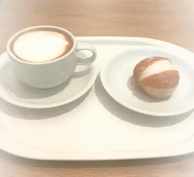 a cup of coffee and a doughnut on a tray at Butiko in Castelluzzo