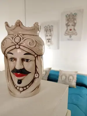 a statue of a mask with a crown on a table at Sea sicily home in Santa Flavia