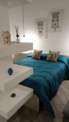 a bedroom with a bed with a blue blanket at Sea sicily home in Santa Flavia