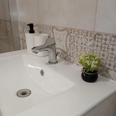a bathroom sink with a faucet and a plant on it at Sea sicily home in Santa Flavia