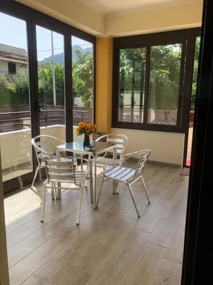 a dining room with a table and chairs and windows at Casa Narciso - Mondello in Mondello